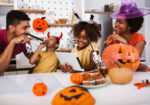 an african american family in their kitchen enjoying halloween treats with halloween decorations surrounding them