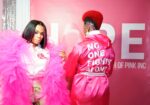 two african american models pose in pink one wearing a pink robe that says "no one fights alone" for breast cancer