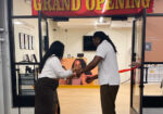 an african american business couple cutting the ribbon at their business grand opening