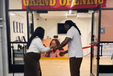 an african american business couple cutting the ribbon at their business grand opening